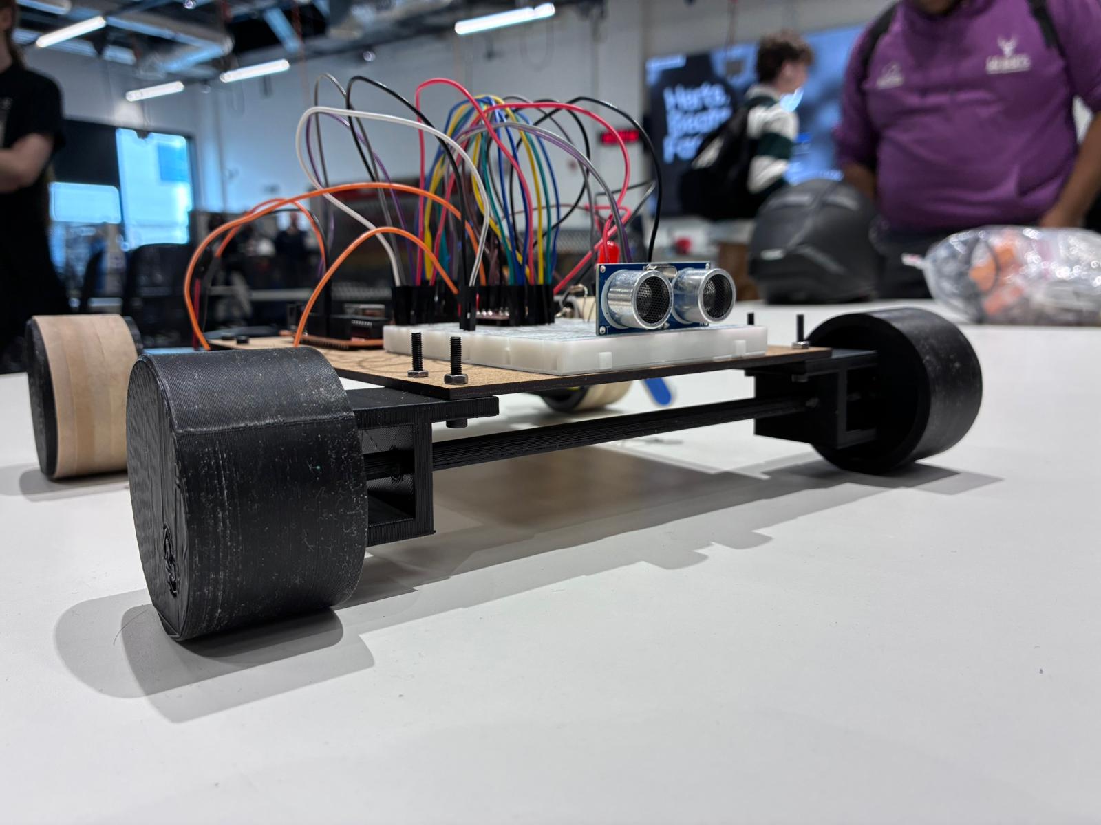 Mars Rover university prototype with 3D printed wheels, exposed wiring and an ultrasonic sensor.
